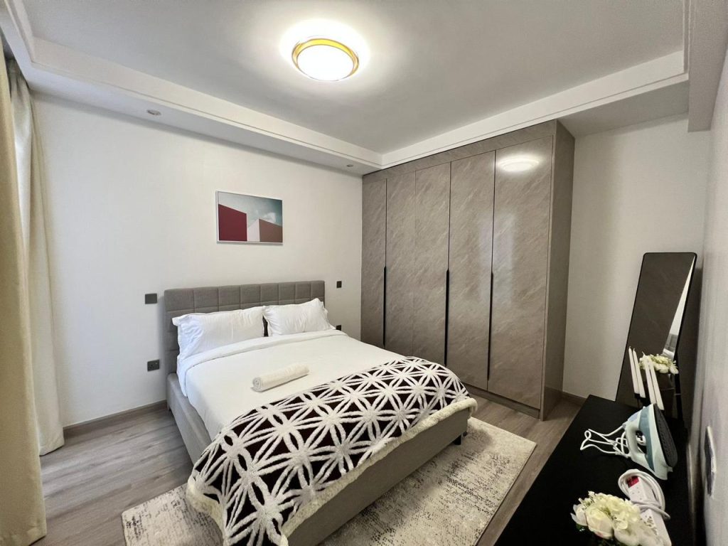 bedroom with a queen size bed, inbuilt wardrobes and a mat at Furnished Apartment near Netherlands Embassy