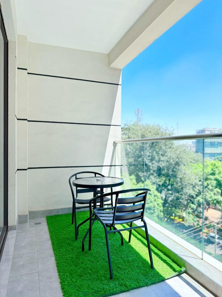 balcony with 2 seats and a medium table at Furnished Apartment near Netherlands Embassy