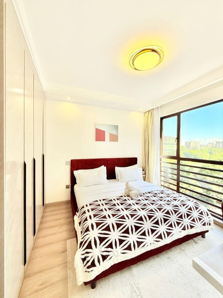 well lit bedroom with a queen size bed and inbuilt wardrobes at Furnished Apartment near Netherlands Embassy