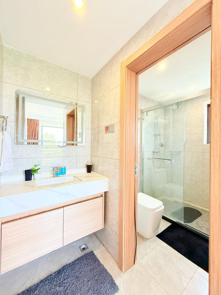 bathroom with the glass shower and toilet separted from the sink with a mirror at Fully Furnished 3 bedroom Apartment in Westlands