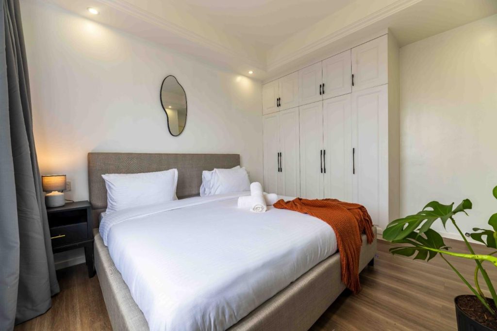 bedroom with a queen size bed ,white linens and inbuilt wardrobes at Family-friendly serviced apartment in Kilimani