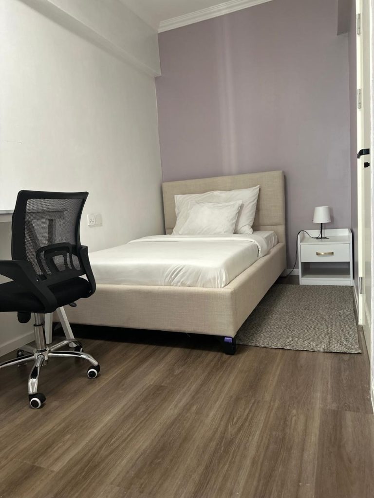 soft lit bedroom with a study desk at Family-friendly serviced apartment in Kilimani