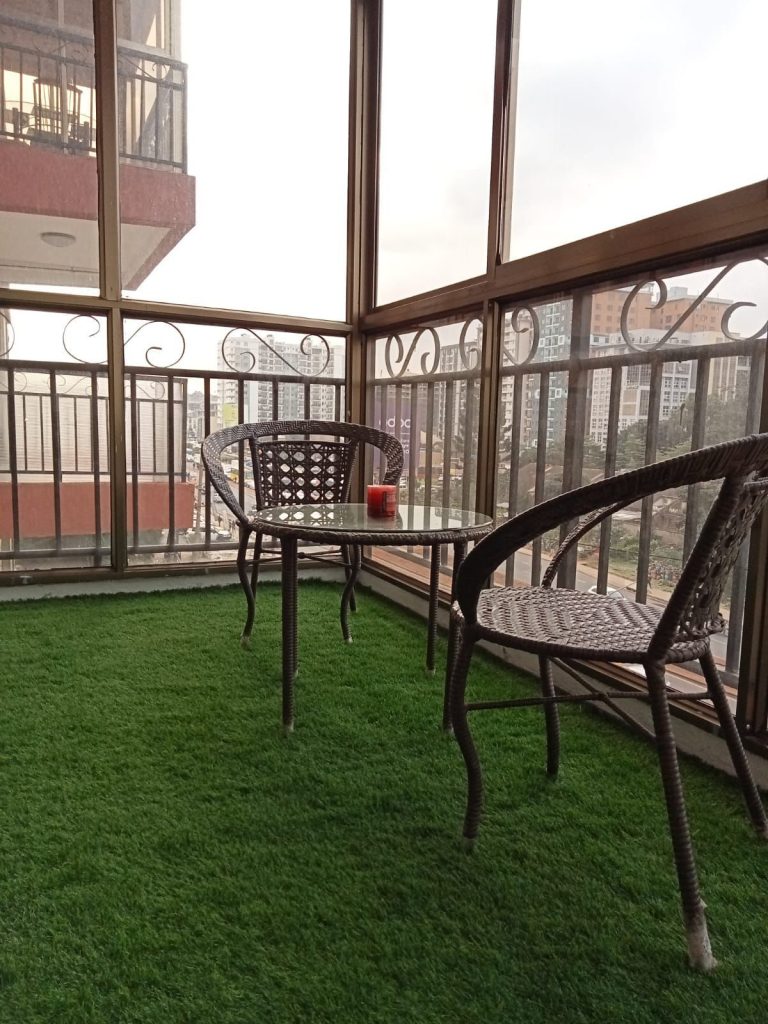 balcony with 2 seats and a table at Budget 2 bedroom furnished apartment Kilimani