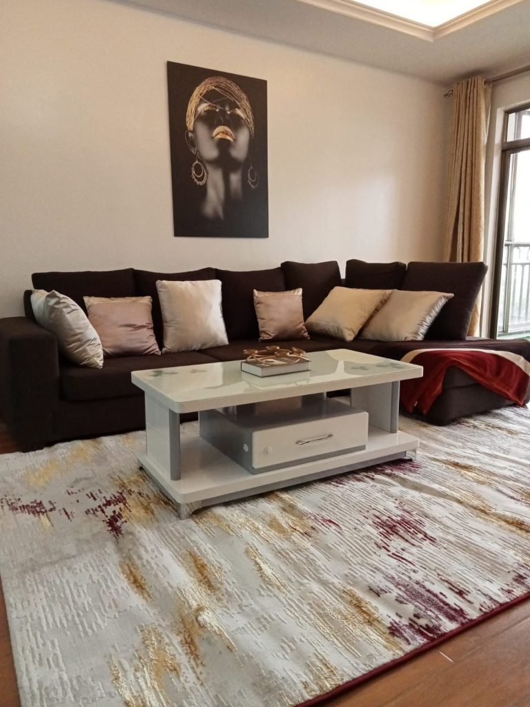 a couch and a coffee on a mat at the Budget 2 bedroom furnished apartment Kilimani