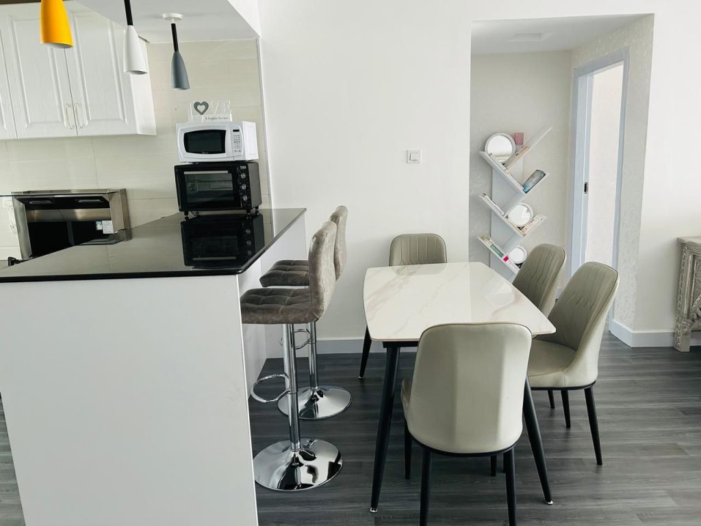a dining table set adjacent to a brakfast bar at the Kilimani 2 bedroom Airbnb with swimming pool