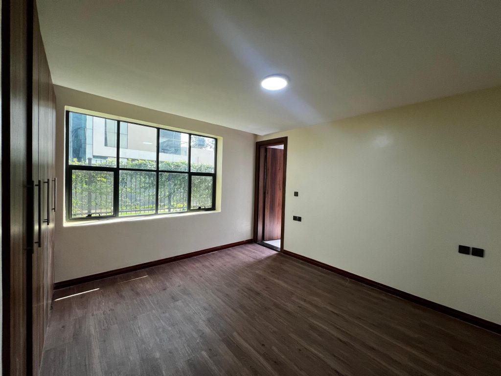 a bedroom with large windows and inbuilt cabinets at Three Bedroom Villas near Lavington Mall,
