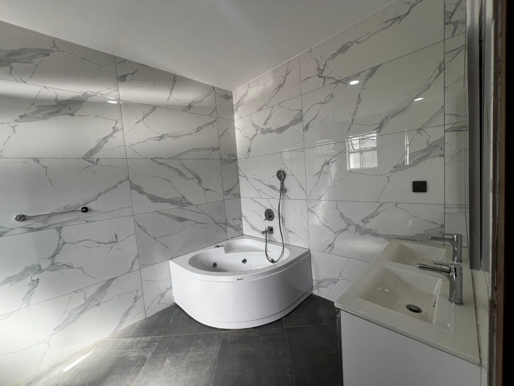 bathtub jacuzzi and a sink in a large bathroom at Three Bedroom Villas near Lavington Mall