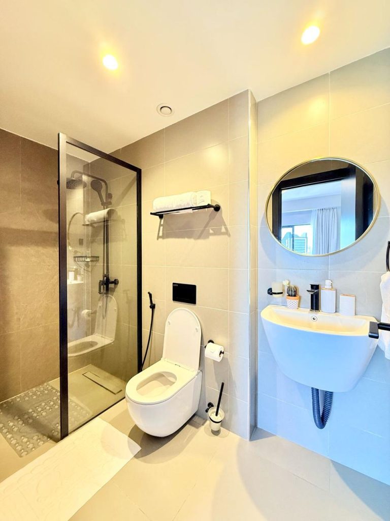 Modern bathroom with a toilet, cubicle glass shower a sink with a mirror at Furnished Apartment for Digital Nomads in Nairobi