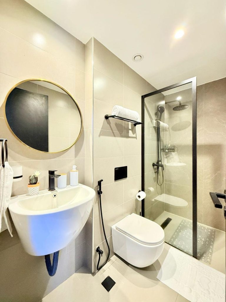 bathroom with cubicle glass shower. atoilet and a sink with a mirror at Furnished Apartment for Digital Nomads in Nairobi