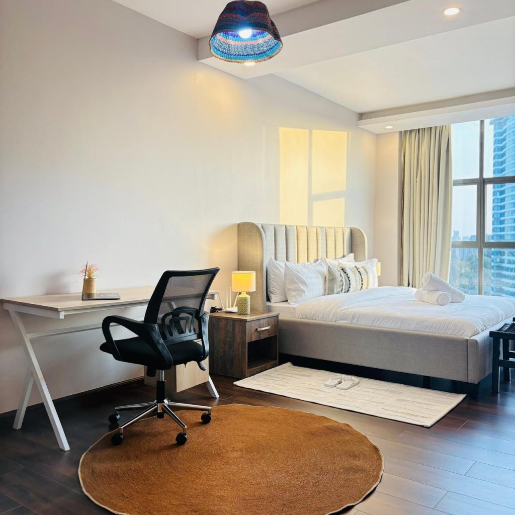 expansive bedroom with a study desk and large windows at Furnished 3 bedroom Apartment in Gated Community