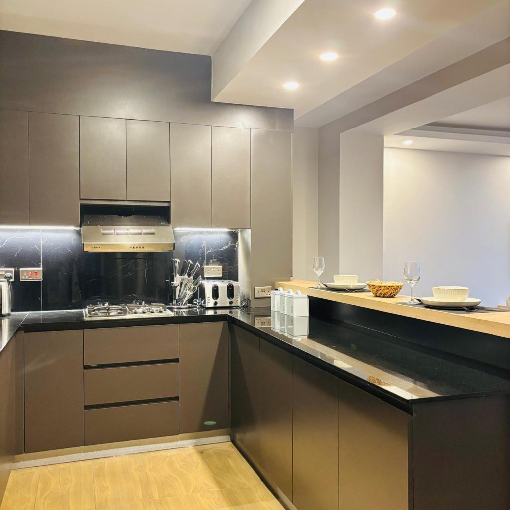 an open plan kitchen fitted with cabinets and appliances at Furnished 3 bedroom Apartment in Gated Community