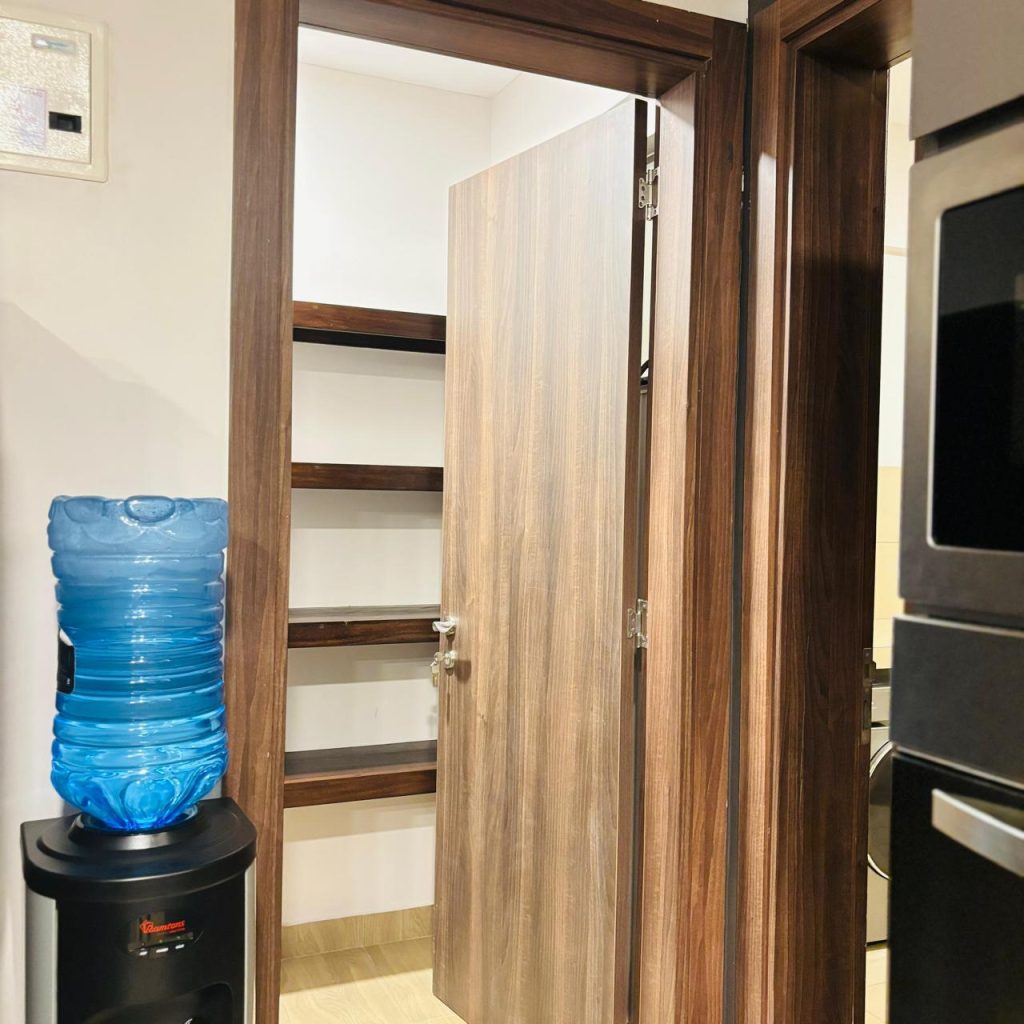 a water dispencer and wooden storage at Furnished 3 bedroom Apartment in Gated Community