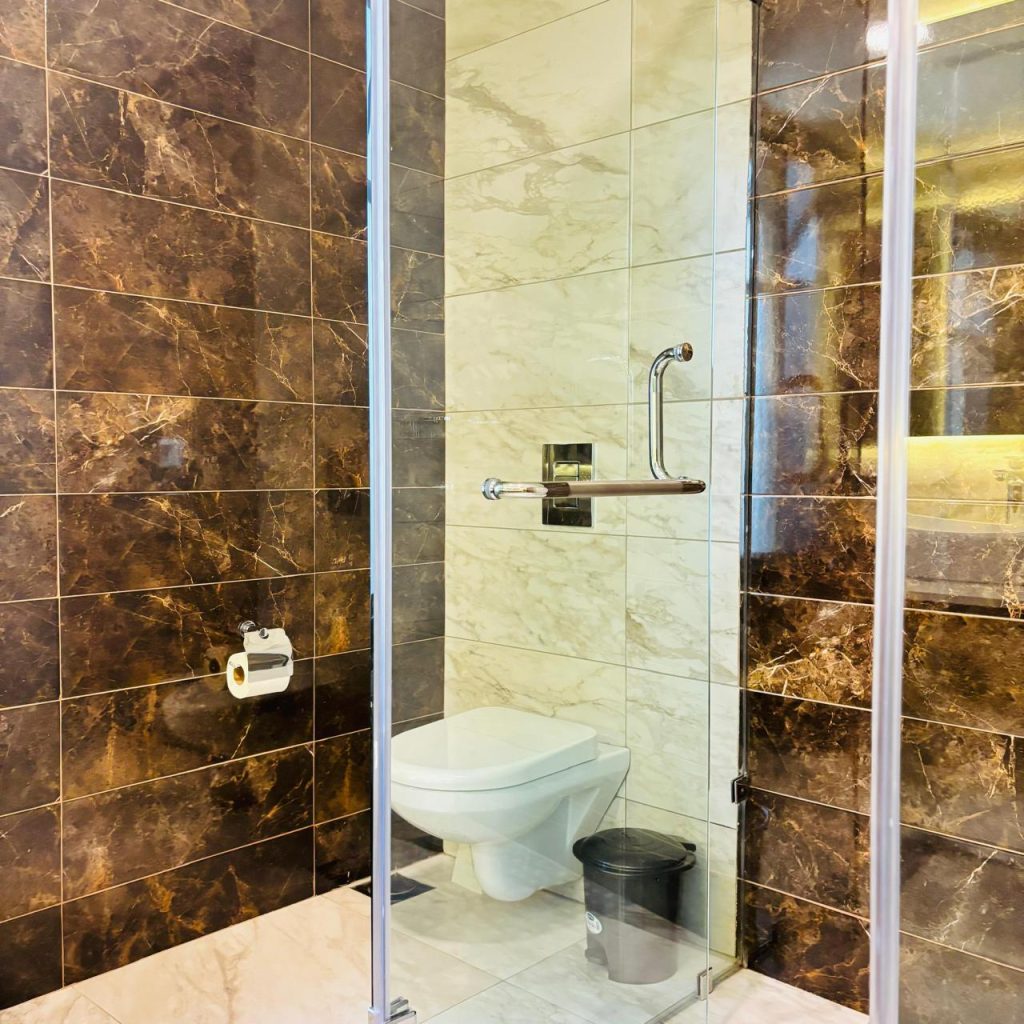 cubicle glass shower and a toilet at Furnished 3 bedroom Apartment in Gated Community