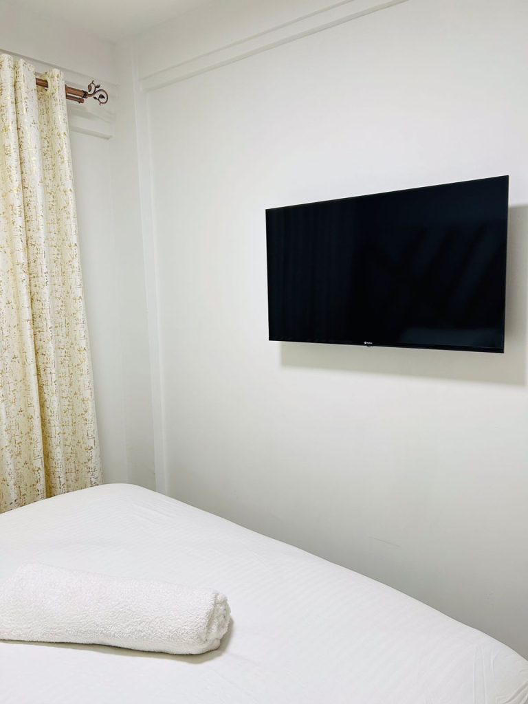 a mounted smart tv in the bedroom at Kilimani serviced apartment for monthly rent