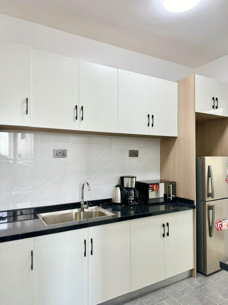 a fitted open plan kitchen with cabinets and applainces at Two Bedroom Furnished Apartment for rent in Nairobi