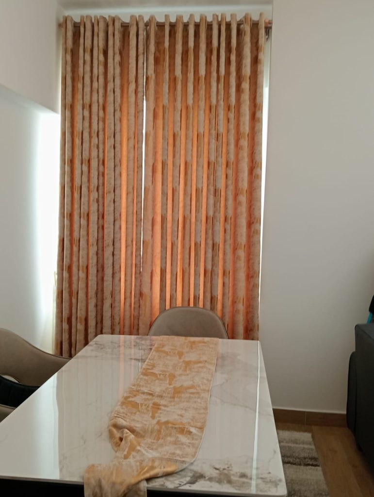 dining area large window covered with a curtain at the Furnished 2-Bedroom Apartment for Daily Rentals in Kilimani
