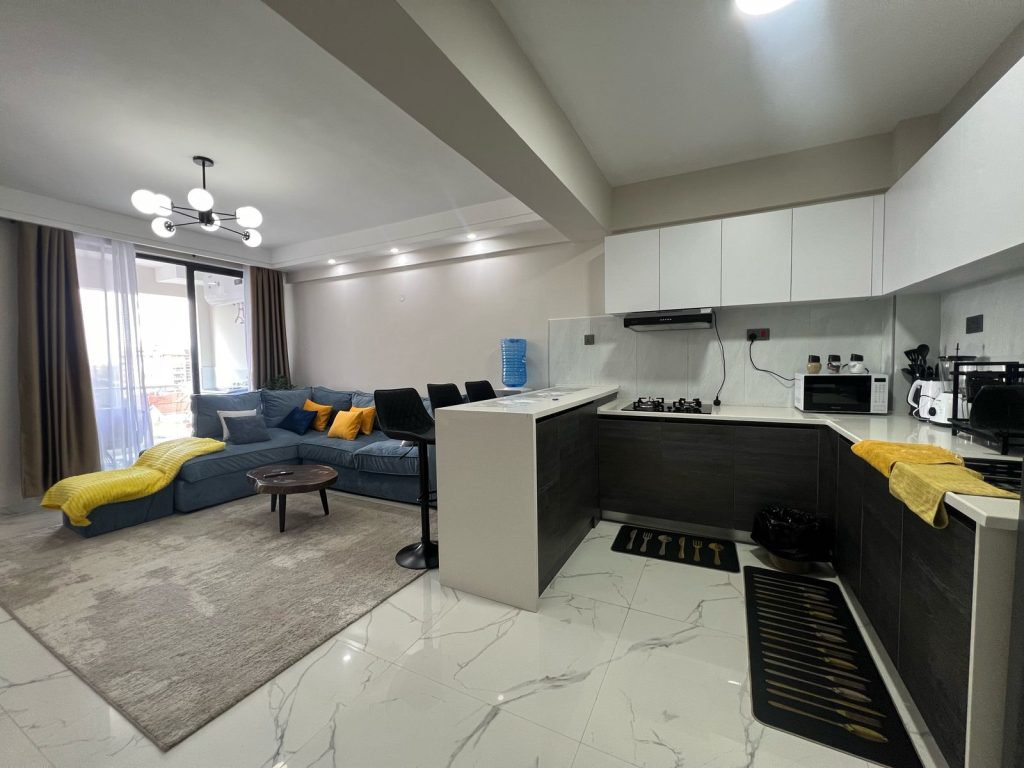 the living room and the open kitchen plan in the Furnished 2 bedroom Apartment Ideal for Extended Stay
