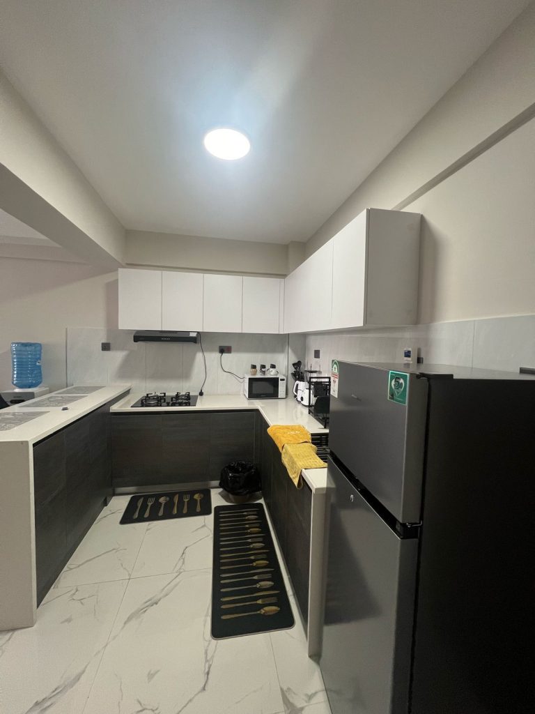 fitted open plan kitchen with white cabinets and appliances at Furnished 2 bedroom Apartment Ideal for Extended Stay