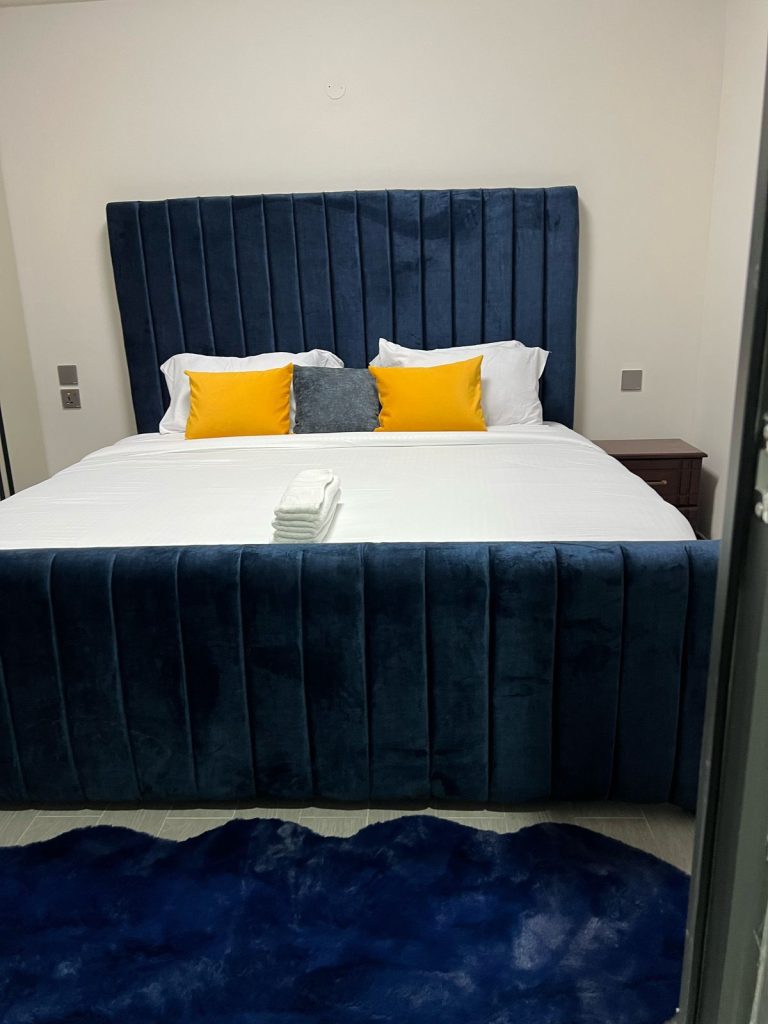 A king size bed with white bedings in the Furnished 2 bedroom Apartment Ideal for Extended Stay