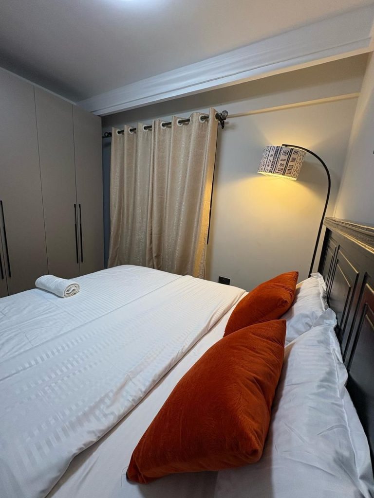 a king size bed and inbuilt wardrobes in the Short Stay Furnished Apartment in Nairobi