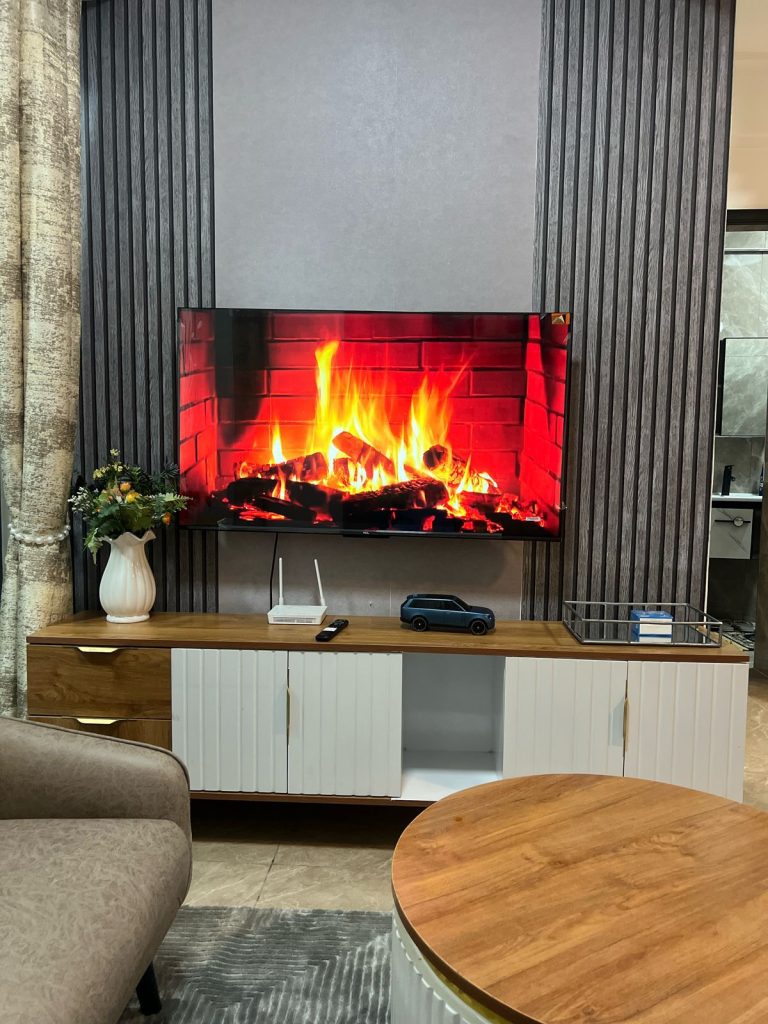 A mounted smart tv and a tv console with internet connection at Furnished Apartment with Rooftop Terrace in Kilimani