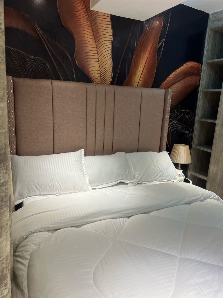 a king bed size bed with white linen at Furnished Apartment with Rooftop Terrace in Kilimani