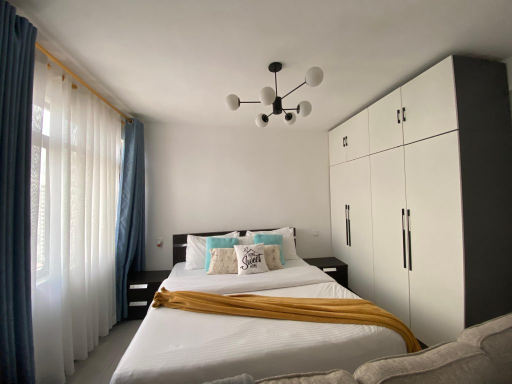 inbuilt wardrobes , a queen size , large windows and chandalier at the Furnished Studio Apartment in Kilimani