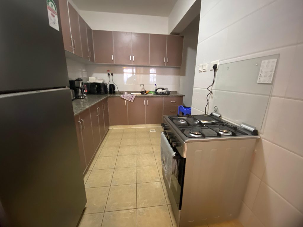 open plan kitchen fitted with cabinets and appliances at Fully Serviced 3 Bedroom Apartment in Kilimani