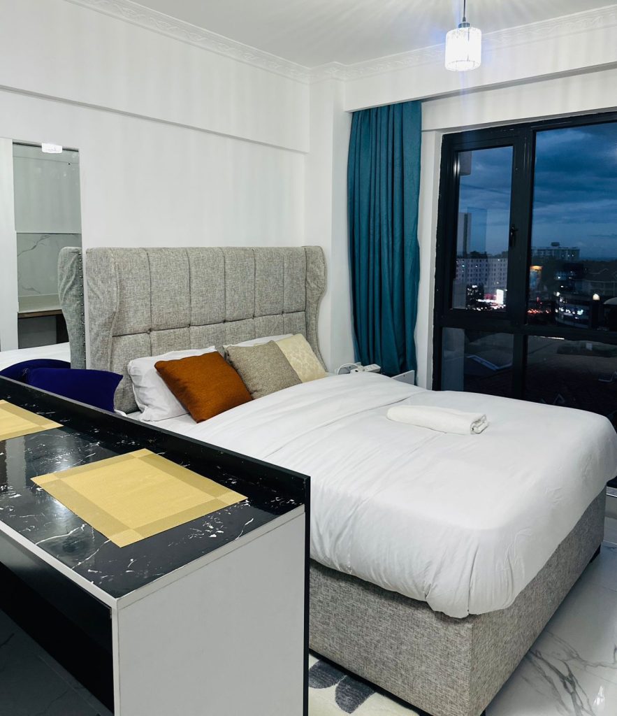 a king size bed with white linen at Furnished Studio Airbnb in Kilimani Nairobi