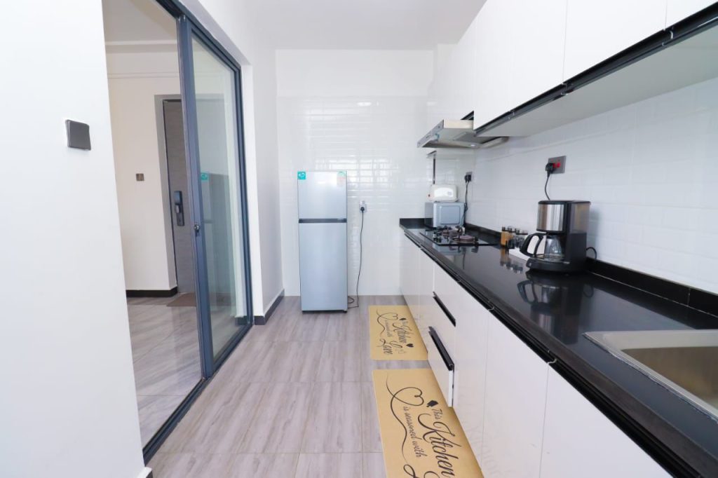 open plan kitchen fitted with appliances and cabinets at Furnished 3 Bedroom Airbnb in Kilimani