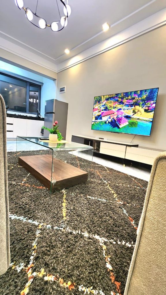 mounted smart tv and glass table at Luxury 1 bedroom apartment near Yaya Kilimani