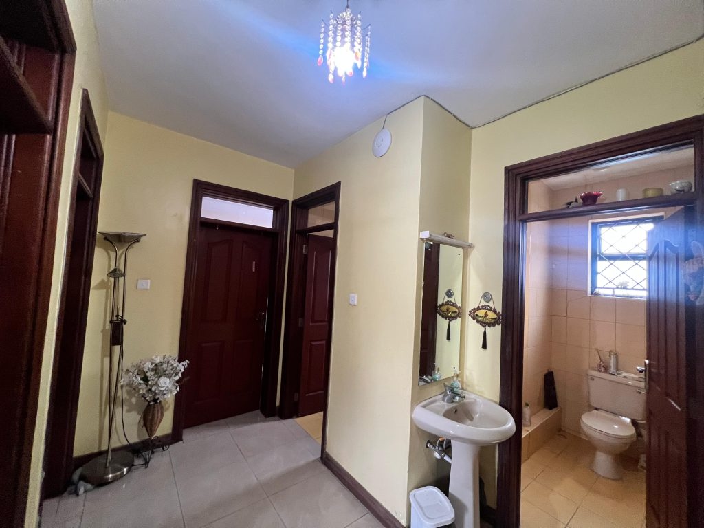common bathroom with shower and a toilet and a sink with a mirror outside in the 3 bedroom apartment at White Oak Park Apartments
