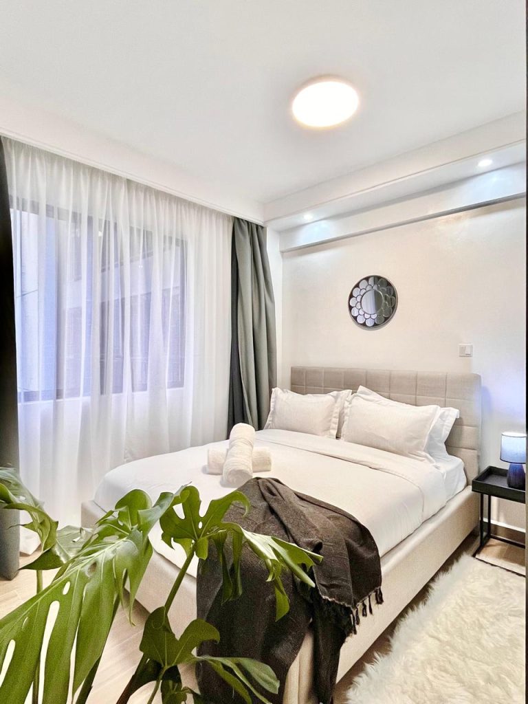 the secomnd bedroom with a queen size bed and white linen in the Short-Term Accomodation Furnished Apartment in Westlands