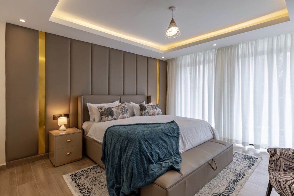 A bedroom well lit with large windows at greenvile apartment