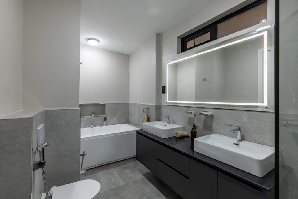 master bedroom with his and hers sink, a bathtub and a toilet at greenvile apartment
