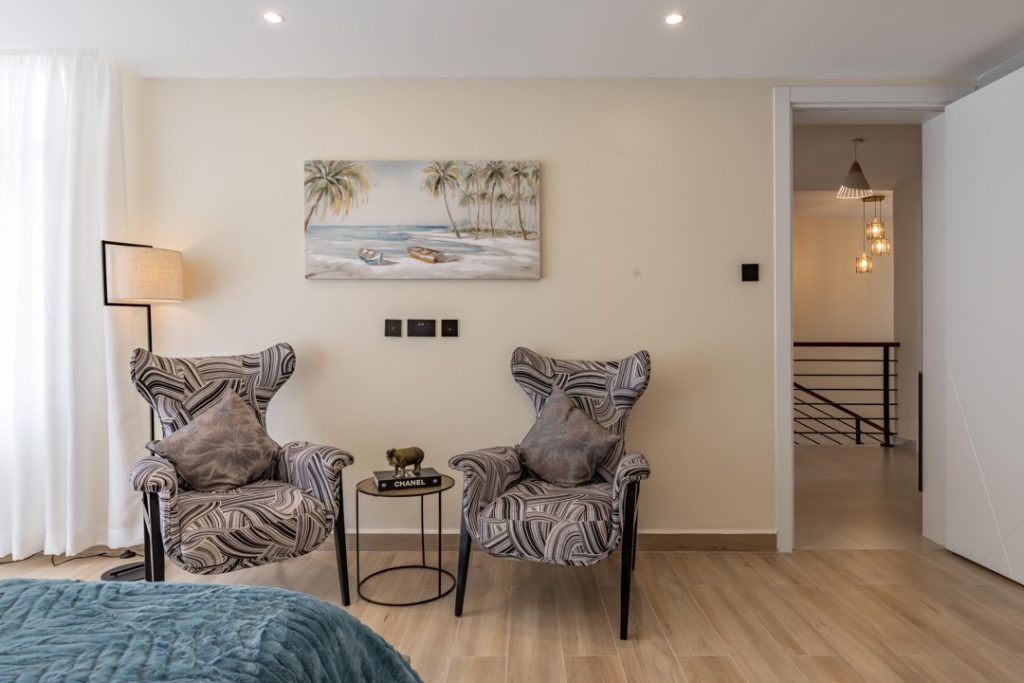2 accent chairs and a table in the bedroom at greenvile apartment
