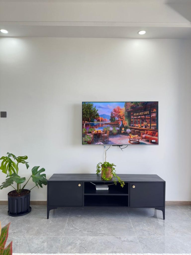 A mounted smart tv and a console under at the Business accommodation near Yaya Centre Kilimani