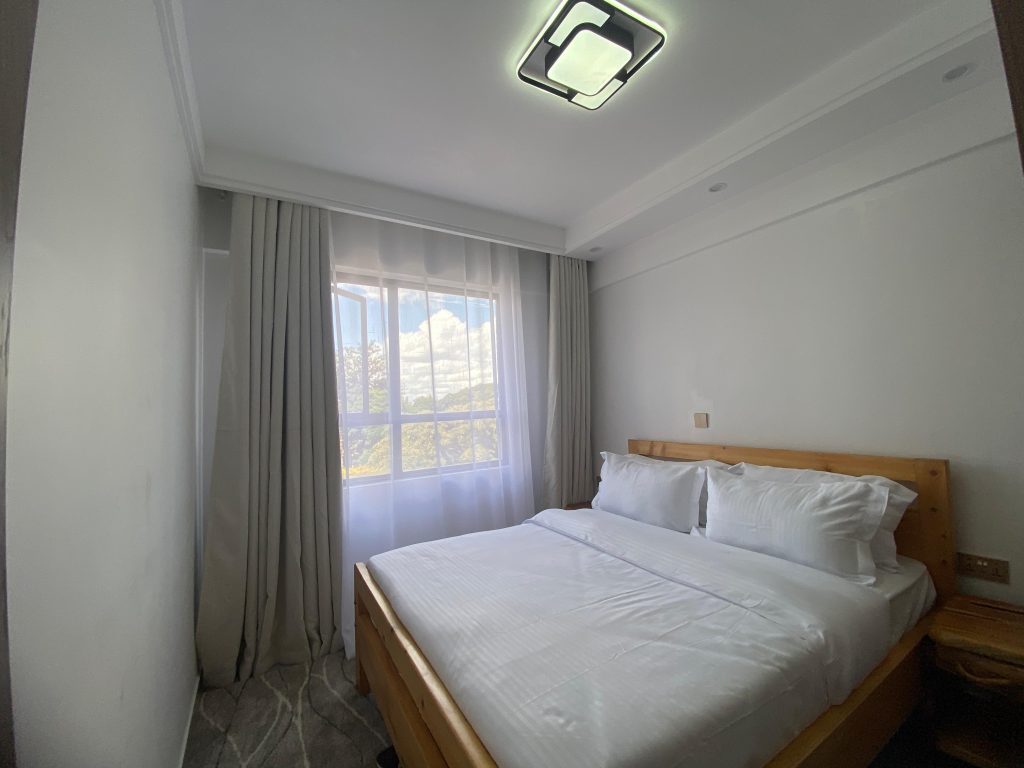 bedroom with large windows view at Serviced apartment in Lavington