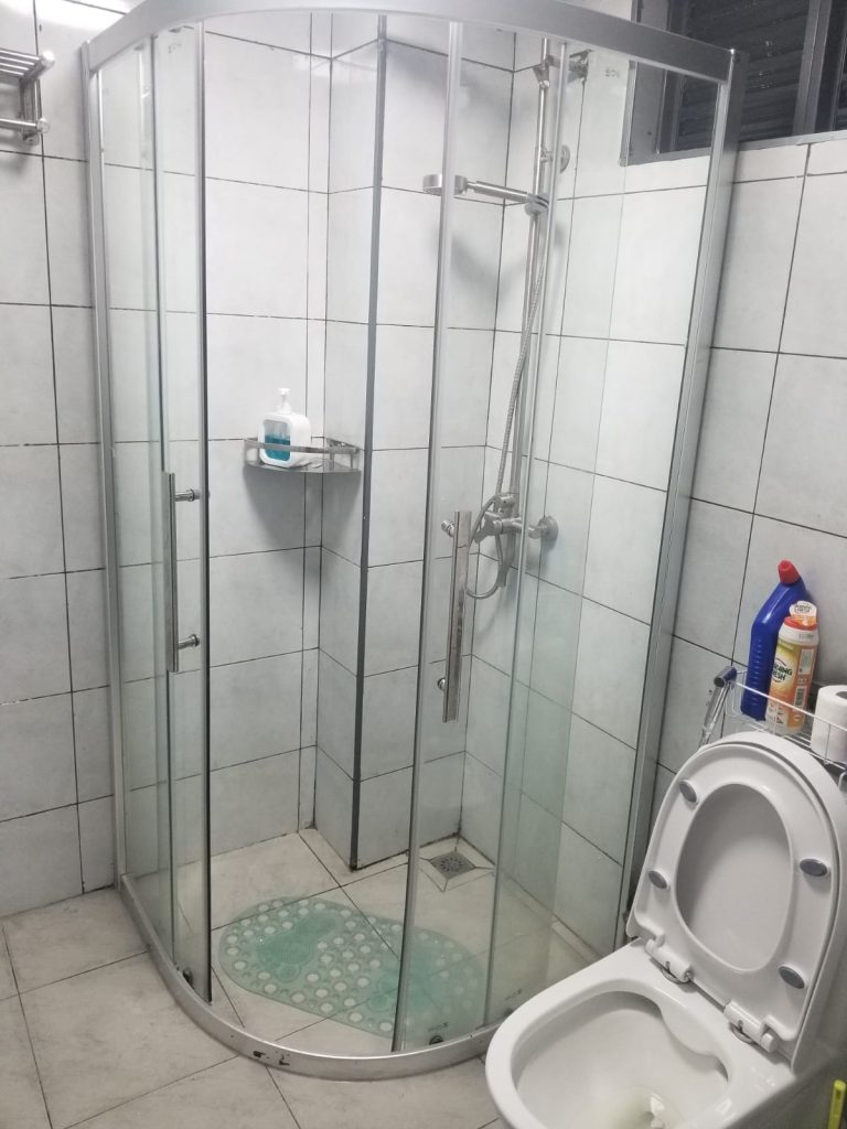 Modern cubicle shower with toilet in the bathroom of an affordable furnished apartment in Kileleshwa Nairobi.