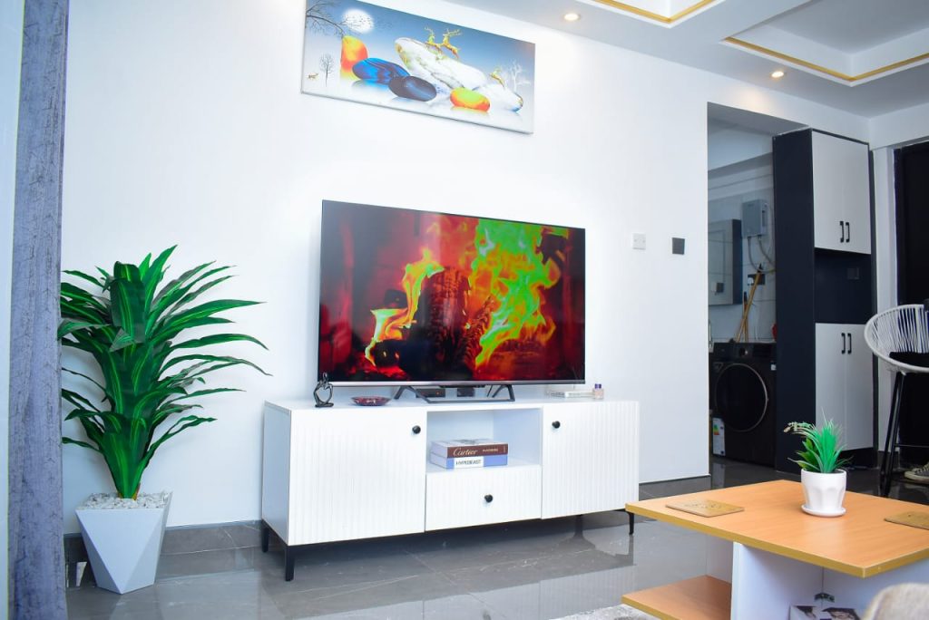 Smart TV placed on a sleek white stand in the living room of an affordable furnished apartment in Kileleshwa Nairobi.