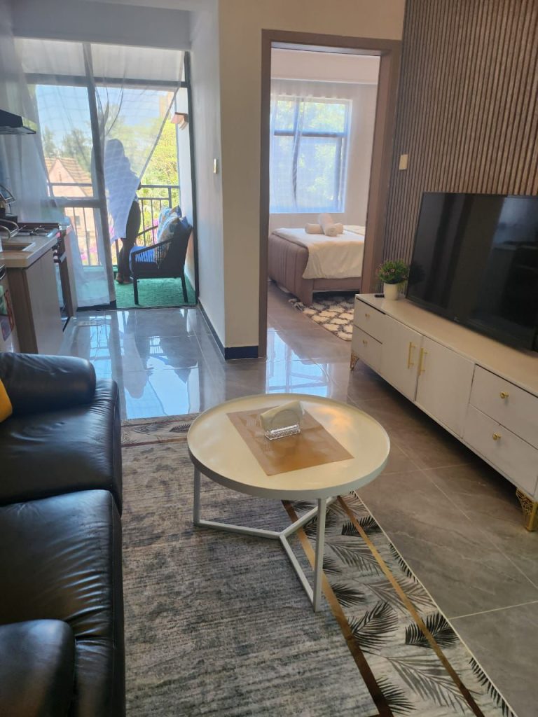 Partial view of the sitting area and an open bedroom in a serviced 2 bedroom apartment in Kilimani Nairobi