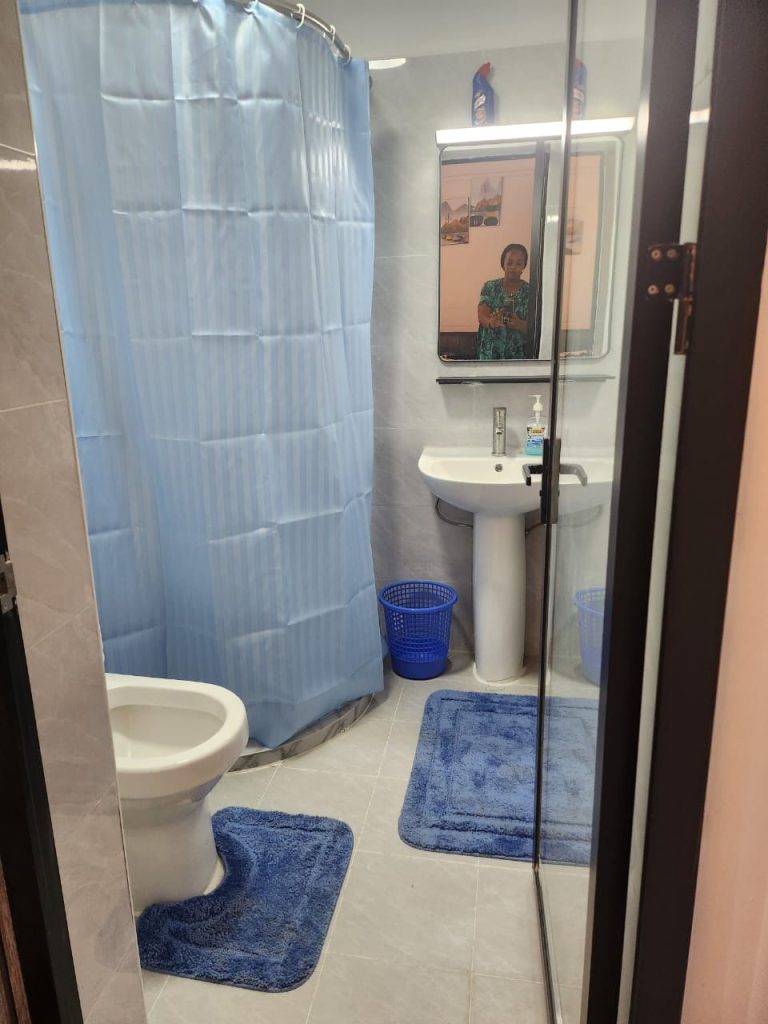 Bathroom with toilet and sink area separated by a sheer in a serviced 2 bedroom apartment in Kilimani Nairobi