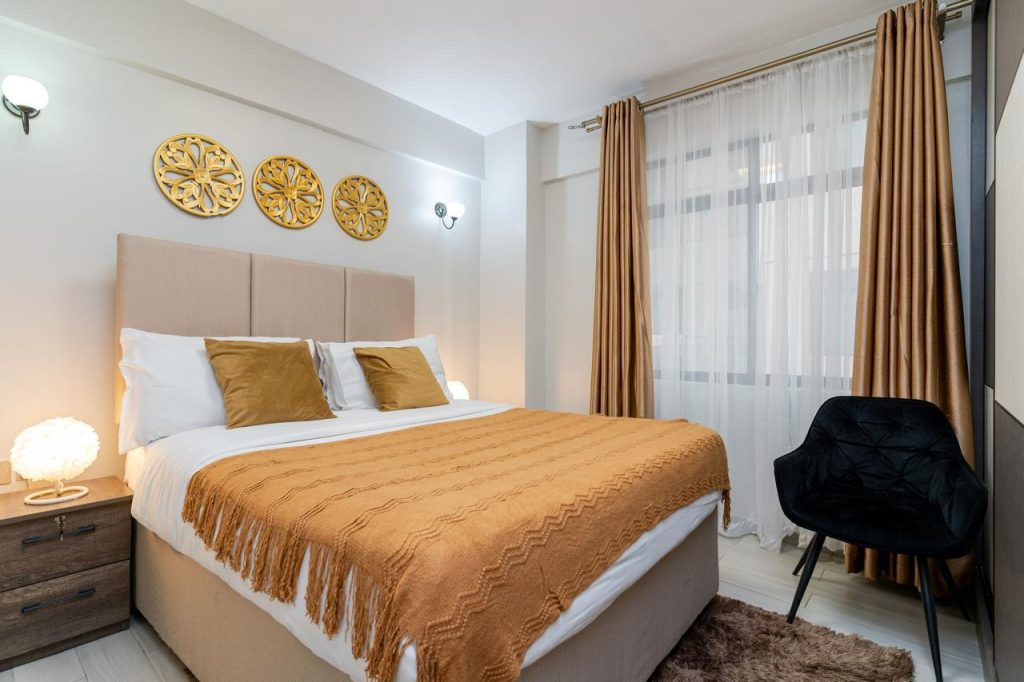 Well-lit queen-sized bedroom with large windows in a furnished apartment in Kileleshwa for rent.