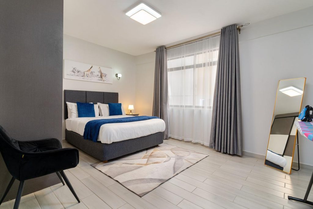 Bright bedroom with king-size bed and large windows in a furnished apartment in Kileleshwa for rent.