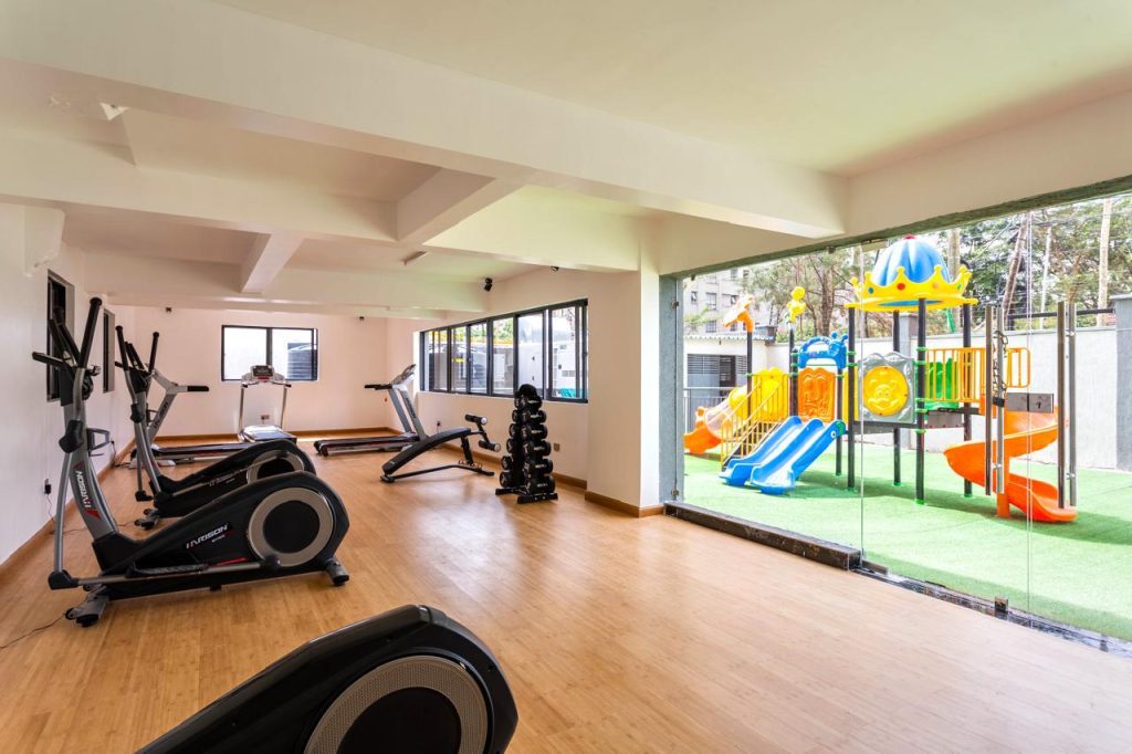 Modern gym and outdoor children’s play area in a furnished apartment complex in Kileleshwa for rent.