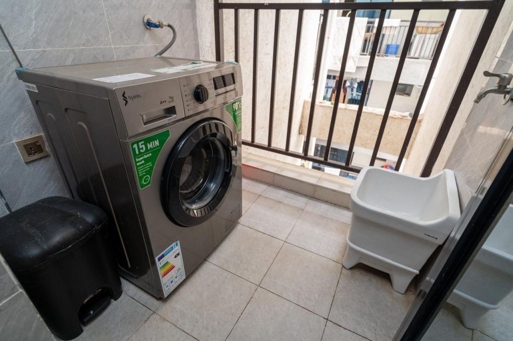 Laundry area featuring a washing machine in a furnished apartment in Kileleshwa for rent.