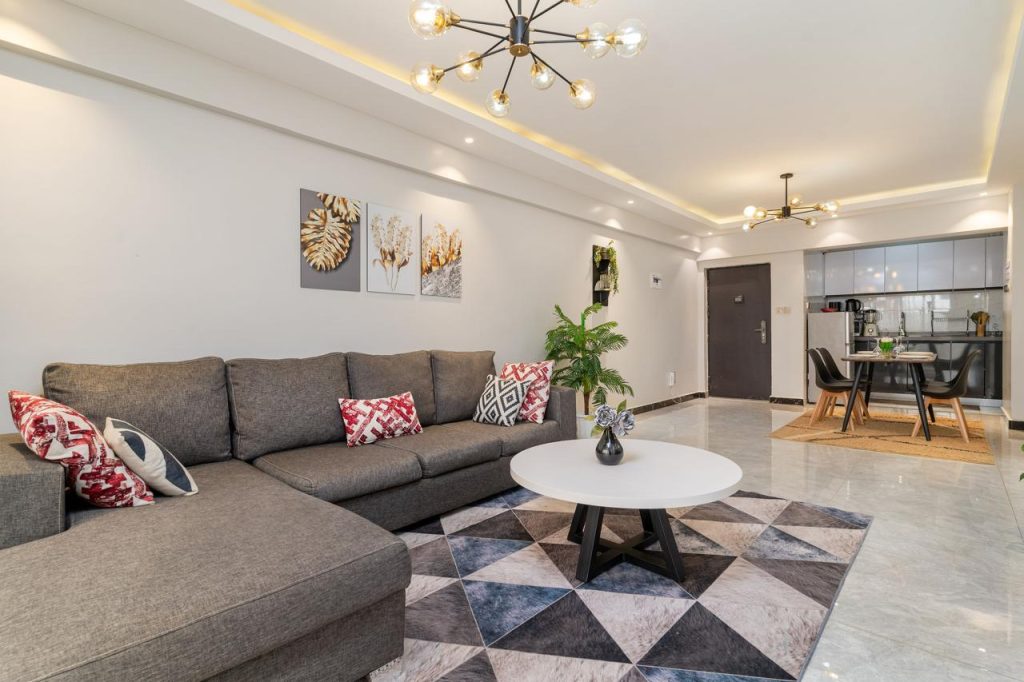 L-shaped couch in a well-lit living area with chandelier in a furnished apartment in Kileleshwa for rent.