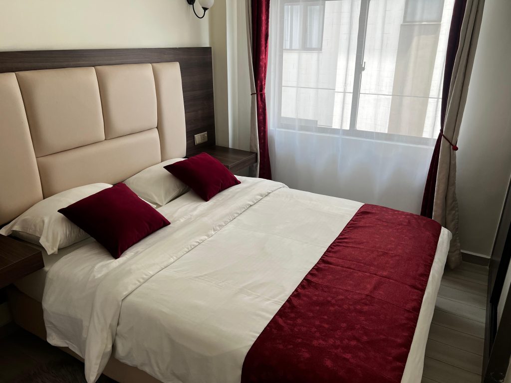Cozy queen-sized bed with white beddings in a short stay 2 bedroom apartment in Kileleshwa Nairobi