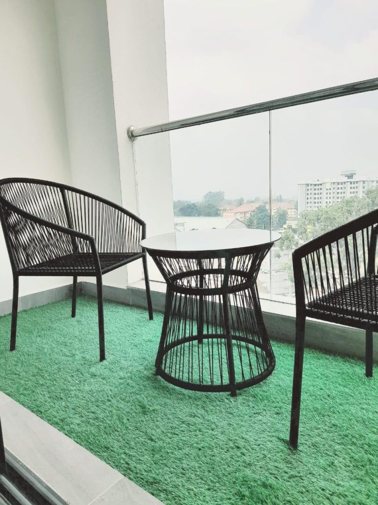 Balcony setup with a table and two chairs, perfect for relaxing – Furnished Apartment for Short Stays in Nairobi.