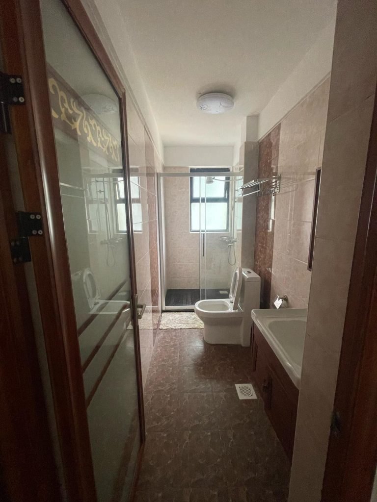 modern bathroom with a shower,toilet and a sink at cheap serviced 2 bedroom apartment in Nairobi